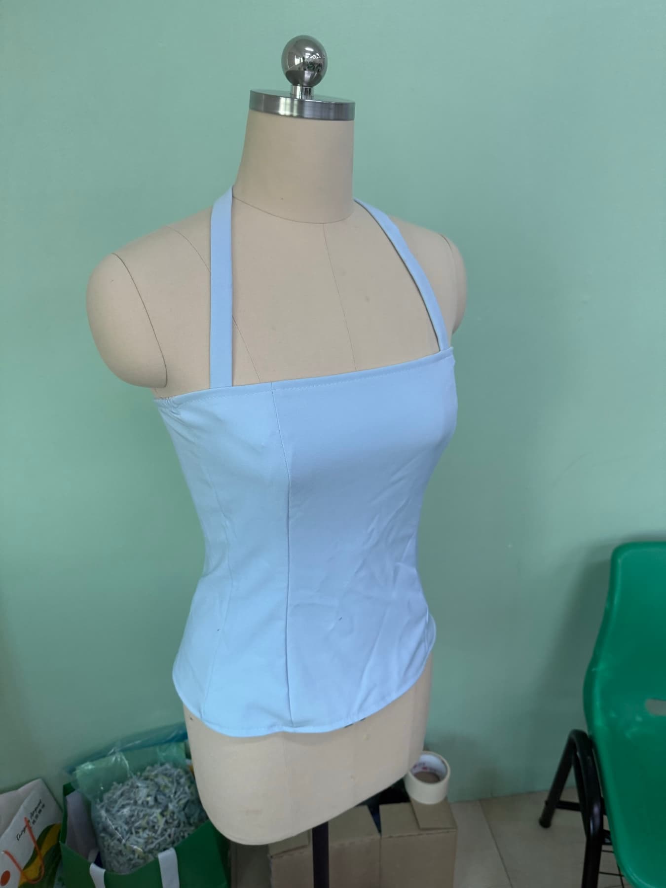 The Versíque top on a dress form, showing the halter neckline and fitted waist